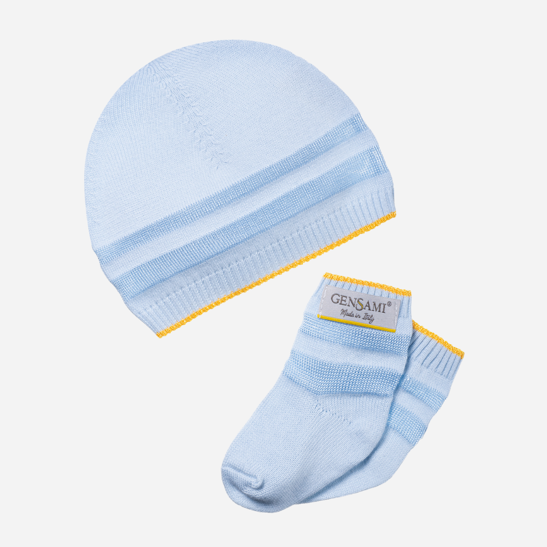 Sold at Bombon and designed by Gensami, a blue newborn layette set including a knit jumpsuit, hat, socks, and matching blanket with yellow stripe detailing.