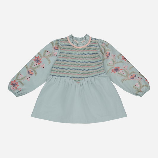 sold at Bombon shop, designed by Bachaa, Blouse/Short dress, Blue color, Organic cotton twill (167 g/m²), Plain lining in organic cotton voile, Long embroidered and elasticated sleeves, Smocked chest, Ruffled collar, Tone-on-tone buttons and belt at the back. front view