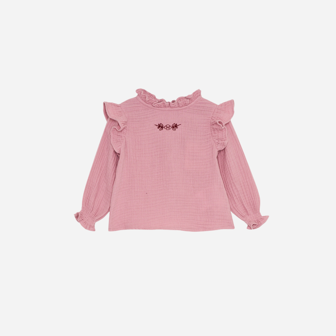 Sold at Bombon shop, this baby girl blouse by The New Society features a soft pink cotton gauze fabric, delicate ruffle details at the shoulders and cuffs, and an embroidered floral motif on the chest for a sweet, timeless look. front