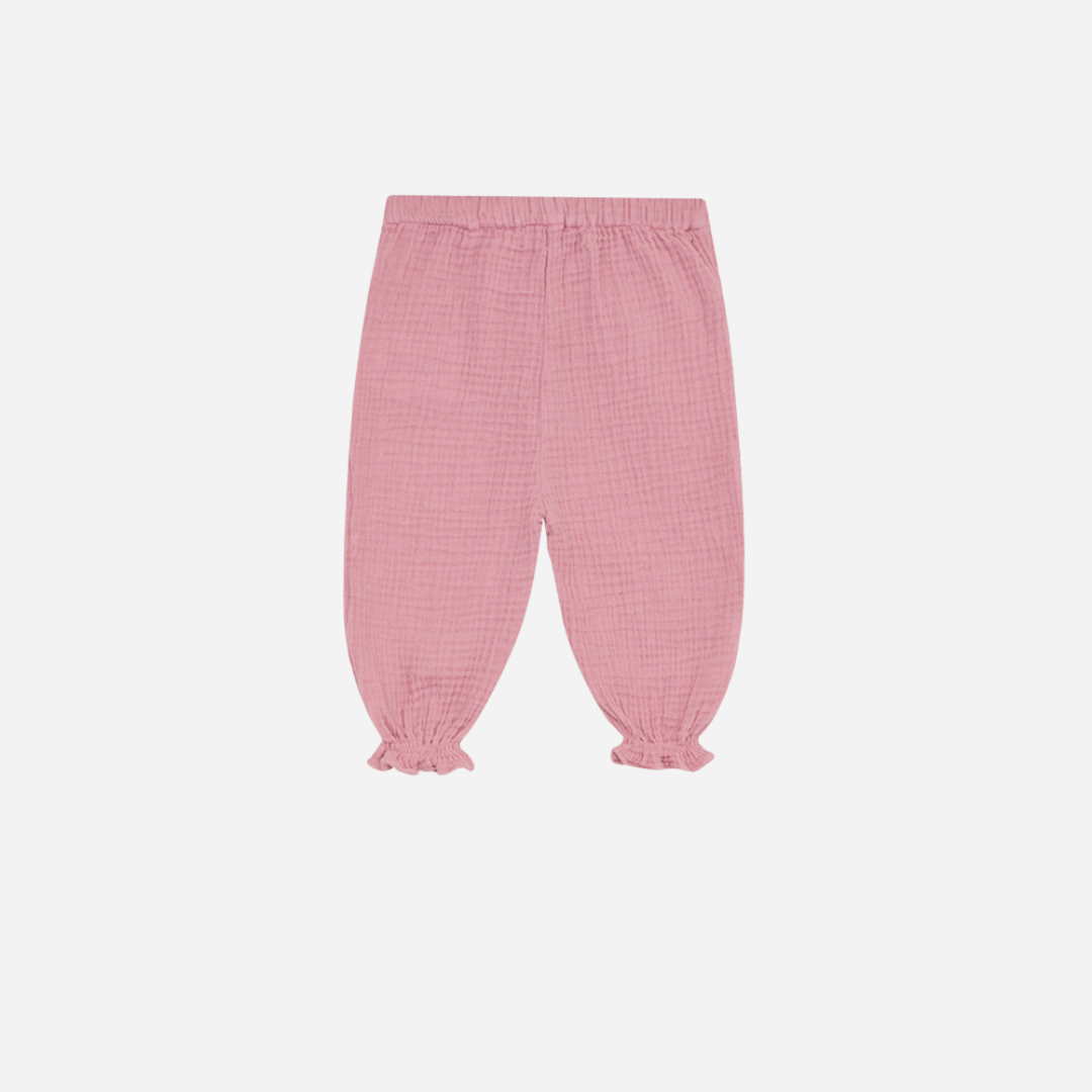 Sold at Bombon shop, these baby girl pants by The New Society are made from soft pink cotton gauze and feature an elastic waistband and ruffled cuffs for a comfy and charming everyday look.