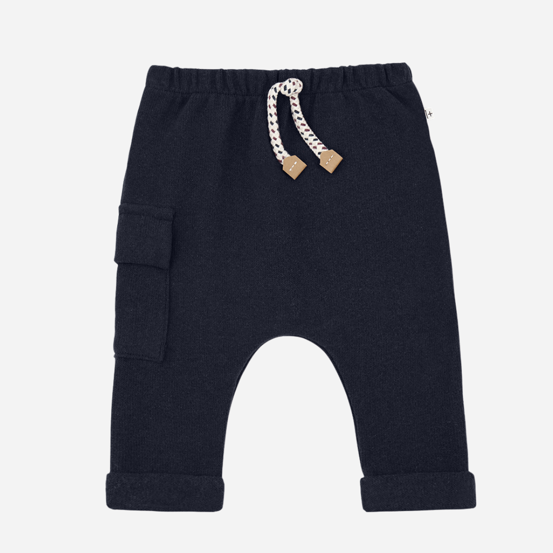 Sold at Bombon shop, designed by 1+ in the family — navy brushed cotton pants with elastic waistband, rope drawstring, side cargo pocket, and rolled cuffs.