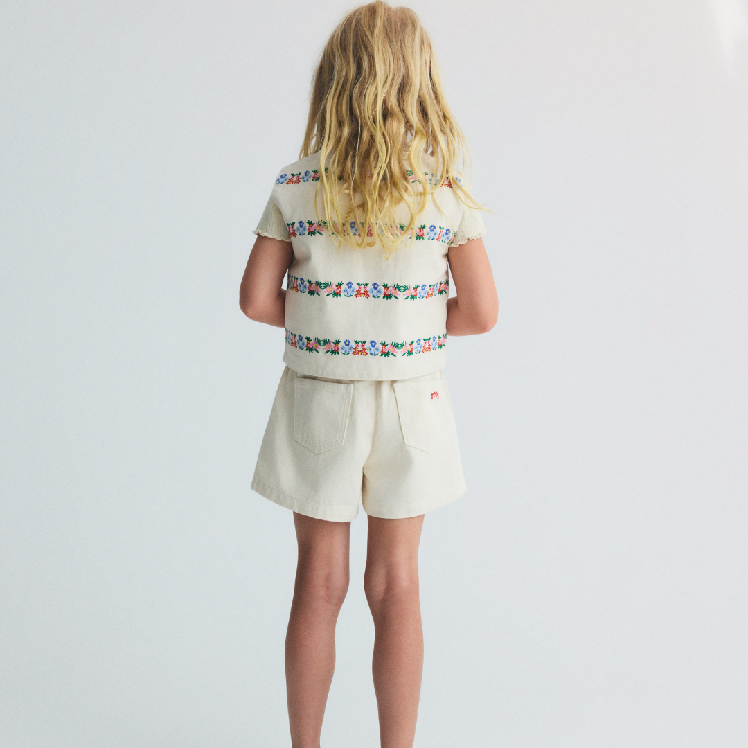 sold at Bombon, designed by The New Society natural denim kids waistcoat with multicolor floral embroidery in 100% BCI cotton matching shorts set