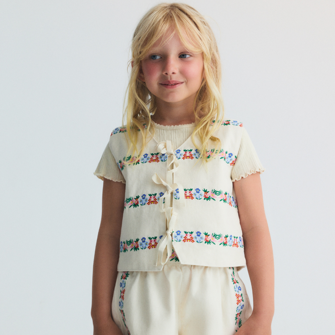 sold at Bombon, designed by The New Society natural denim kids waistcoat with multicolor floral embroidery in 100% BCI cotton matching shorts set
