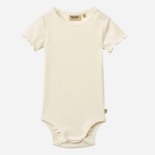 Sold at Bombon Shop, designed by Wheat, ivory organic cotton short sleeve baby bodysuit with a soft minimal silhouette.