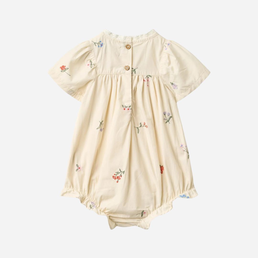 Sold at Bombon Shop, designed by Wheat, ivory organic cotton baby romper with delicate embroidered flowers and soft gathered detailing. back
