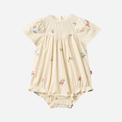 Sold at Bombon Shop, designed by Wheat, ivory organic cotton baby romper with delicate embroidered flowers and soft gathered detailing.