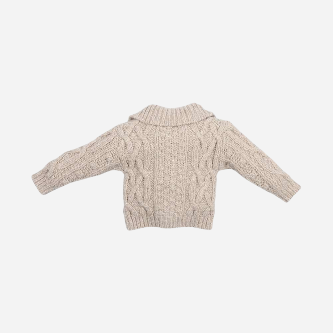 Sold at Bombon shop, this baby cardigan by The New Society features a classic cable knit design with toggle button closures and a shawl collar—ideal for layering in cooler months. back