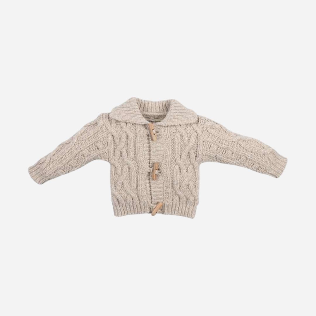Sold at Bombon shop, this baby cardigan by The New Society features a classic cable knit design with toggle button closures and a shawl collar—ideal for layering in cooler months. front