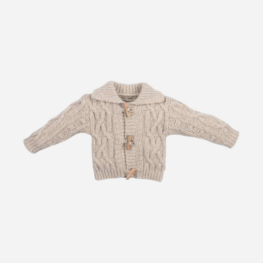 Sold at Bombon shop, this baby cardigan by The New Society features a classic cable knit design with toggle button closures and a shawl collar—ideal for layering in cooler months. front