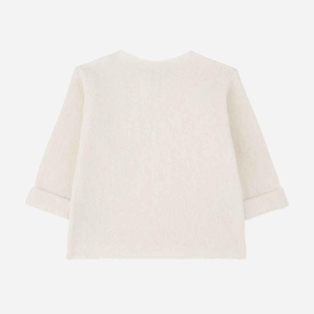 Sold at Bombon shop, designed by 1+ in the family — cream knit baby shirt with long sleeves, textured patch pocket, and single-button collar. back