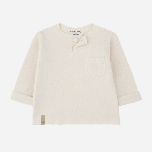 Sold at Bombon shop, designed by 1+ in the family — cream knit baby shirt with long sleeves, textured patch pocket, and single-button collar. front