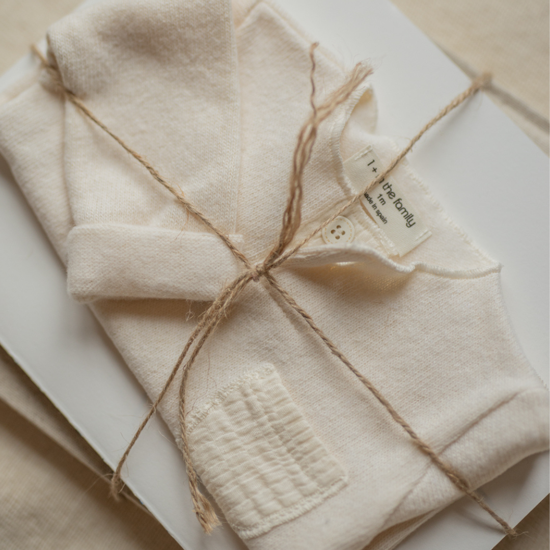 Folded beige fabric with twine and a label on a neutral background