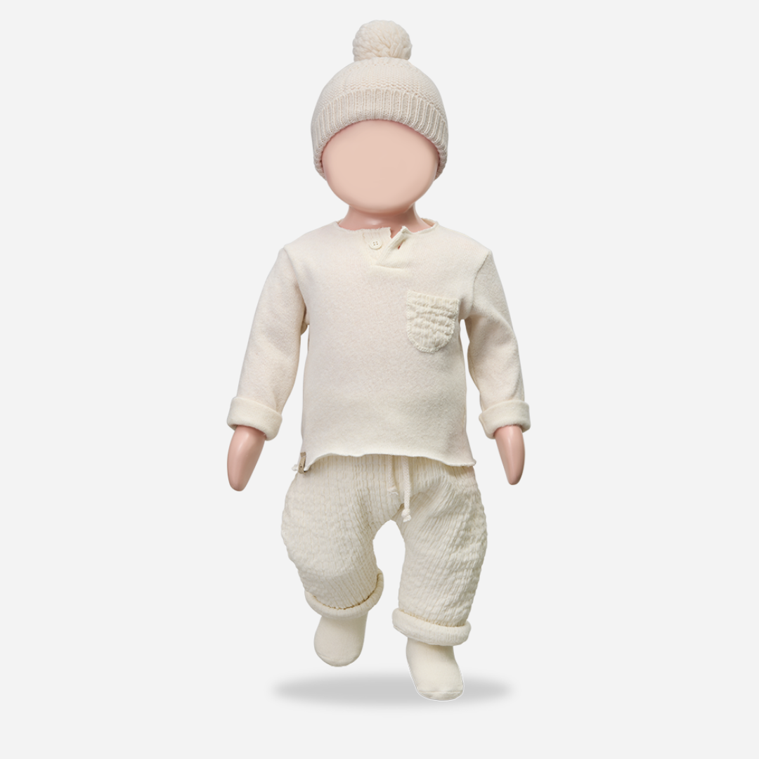Sold at Bombon shop, designed by 1+ in the family — cream textured cotton muslin baby pants with rolled cuffs and adjustable drawstring waist. mannequin