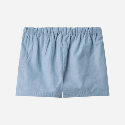 Sold at Bombon Shop, designed by Wheat, blue chambray organic cotton kids shorts with elastic waistband and drawstring detail.