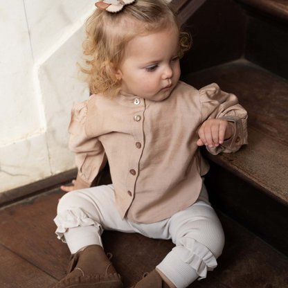 Sold at Bombon shop, designed by Donsje from Amsterdam, these leggings in a soft sand color and ruffle detail in the bottom leg for baby gris and toddler are the perfect piece for pre fall all the way through winter.  model view