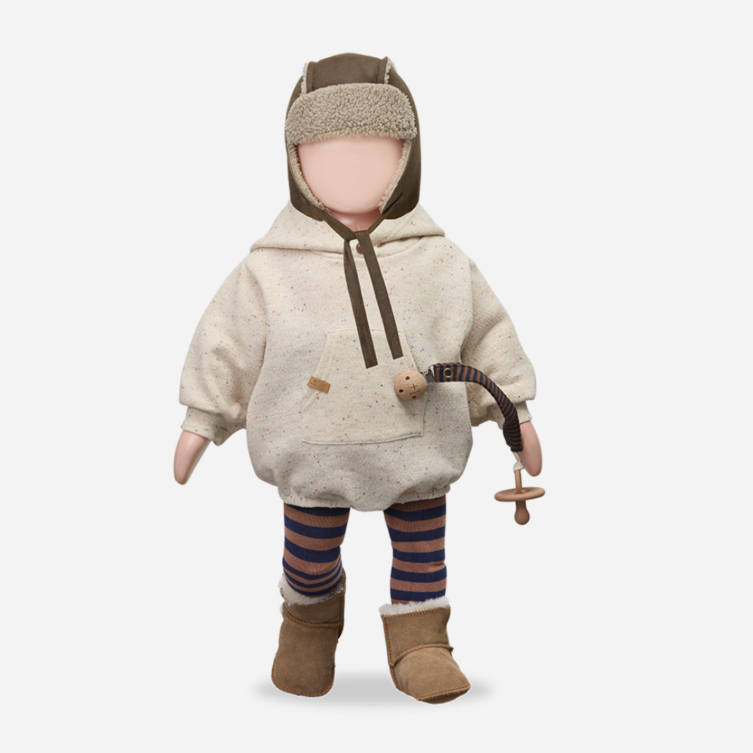 Sold at Bombon shop, designed by 1+ in the family — speckled cream baby romper with hood, long sleeves, and front kangaroo pocket. mannequin