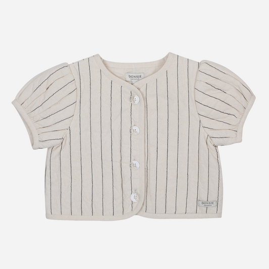 Sold at Bombon shop, designed by Donsje from Amsterdam, this baby and toddler girl jacket is the perfect pre-fall and transition jacket. In a warm white with thin stitched stipes makes it the perfect stylish top.   front view