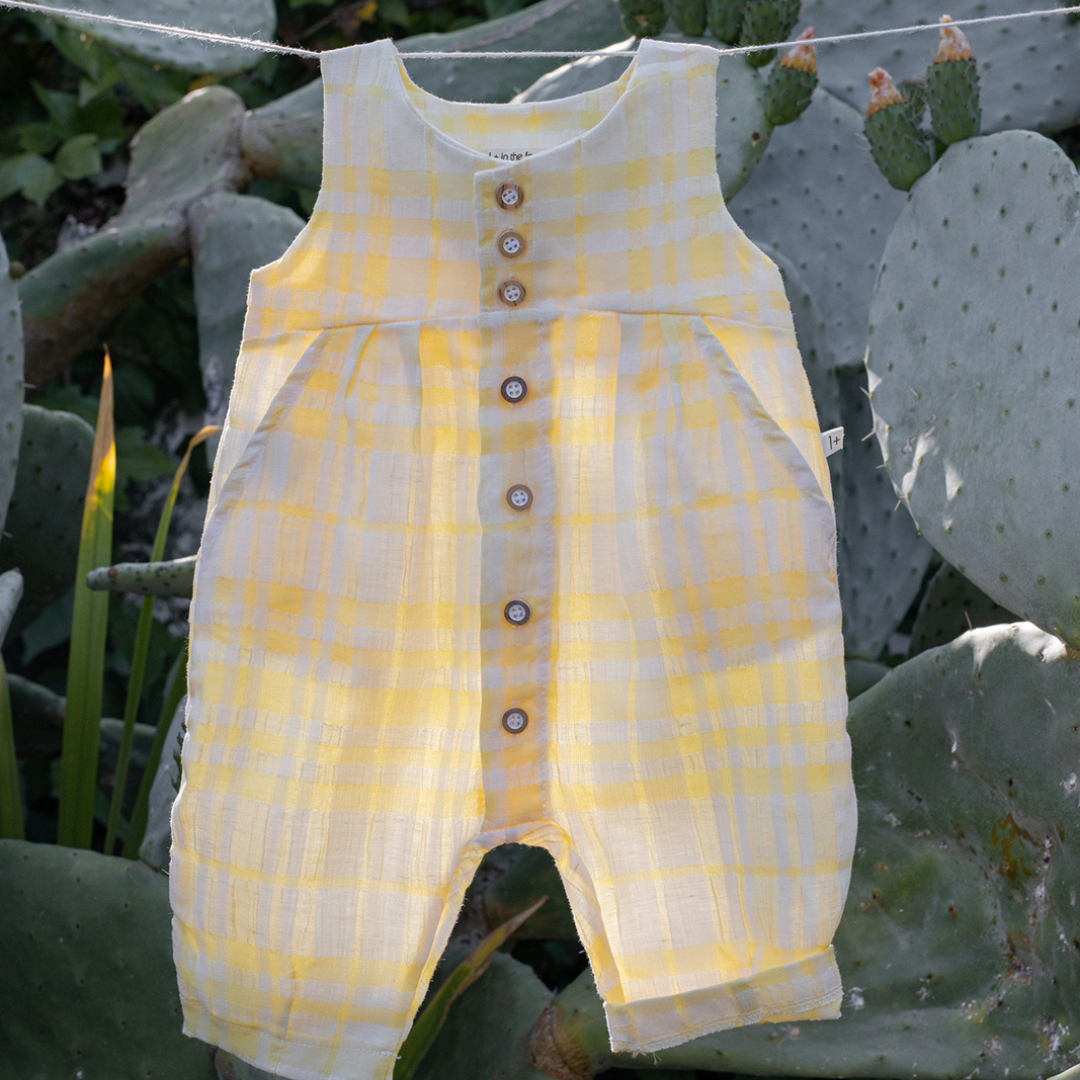 Sold at Bombon Shop, designed by 1+ in the family, lemon check baby overall with front button detail and soft cotton fabric.
