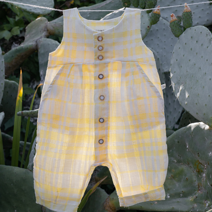 Sold at Bombon Shop, designed by 1+ in the family, lemon check baby overall with front button detail and soft cotton fabric.