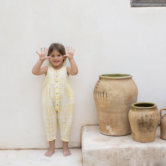 Sold at Bombon Shop, designed by 1+ in the family, lemon check baby overall with front button detail and soft cotton fabric.