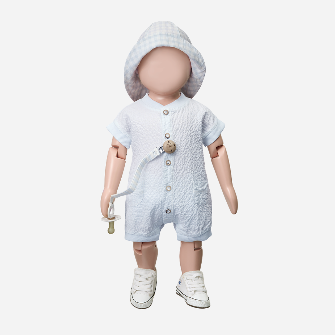 Sold at Bombon Shop, designed by 1+ in the family, misty blue baby overall with front button detail and textured cotton fabric.