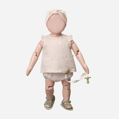 Sold at Bombon Shop, designed by 1+ in the family, blossom pink baby blouse with flutter sleeves and matching bloomers in textured cotton fabric.