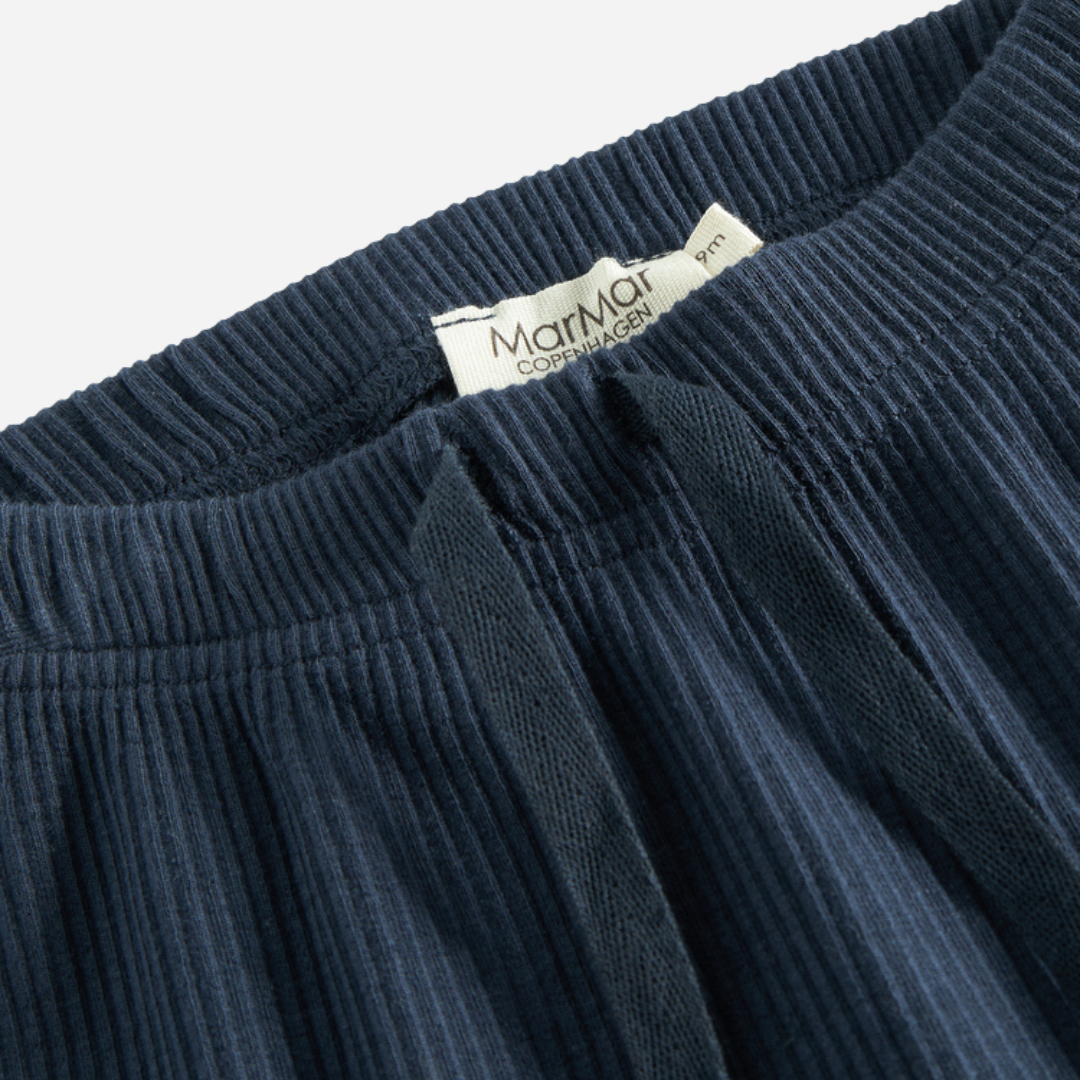 Sold at Bombon shop, designed by MarMar Copenhagen — navy ribbed organic cotton baby pants with drawstring, part of a matching set.