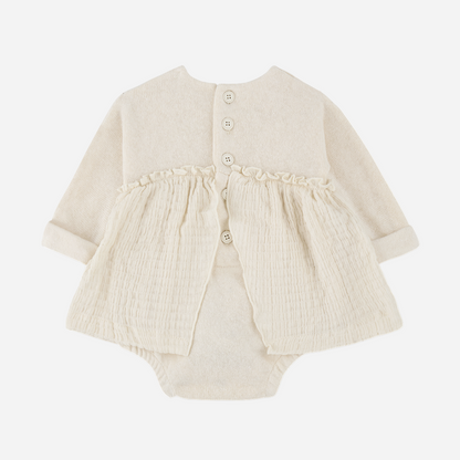 Sold at Bombon shop, designed by 1+ in the family — cream long-sleeve baby dress romper with ruffled gauze skirt and knit bodice. back