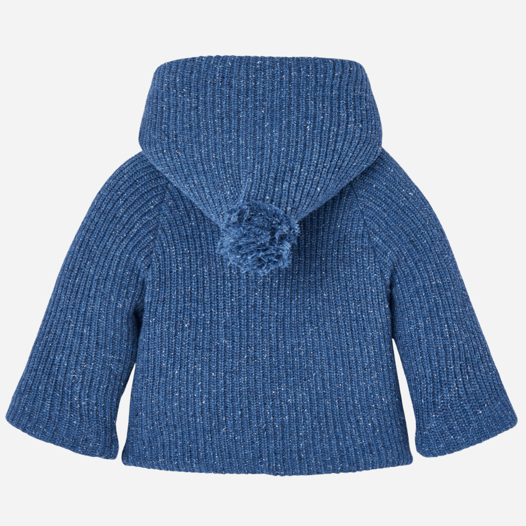 Sold at Bombon shop, designed by Paz Rodriguez. Baby and toddler knit coat in blue with wrap closure, side ties, buttons, and beige lining. back