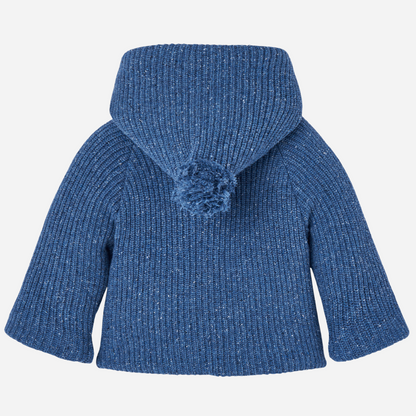 Sold at Bombon shop, designed by Paz Rodriguez. Baby and toddler knit coat in blue with wrap closure, side ties, buttons, and beige lining. back