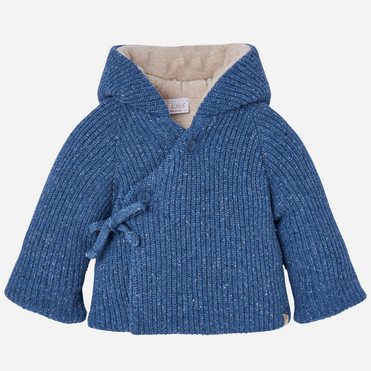 Sold at Bombon shop, designed by Paz Rodriguez. Baby and toddler knit coat in blue with wrap closure, side ties, buttons, and beige lining. front