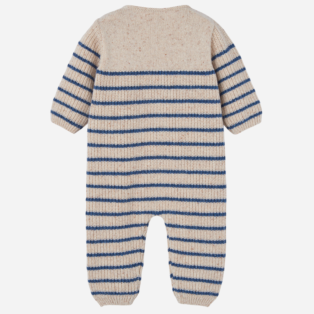 Sold at Bombon shop, designed by Paz Rodriguez, beige knit baby jumpsuit with blue horizontal stripes and front button closure.