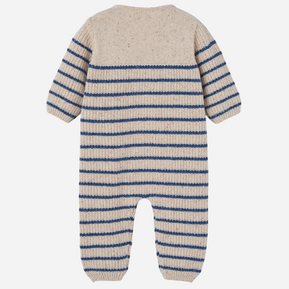 Sold at Bombon shop, designed by Paz Rodriguez, beige knit baby jumpsuit with blue horizontal stripes and front button closure.