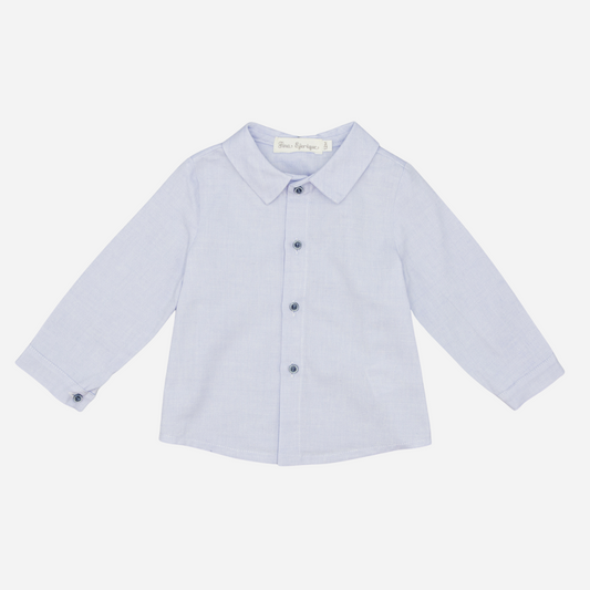 Sold at Bombon shop, designed by Fina Ejerique, a light-blue cotton baby shirt with rounded collar, long sleeves, and matching buttons. front