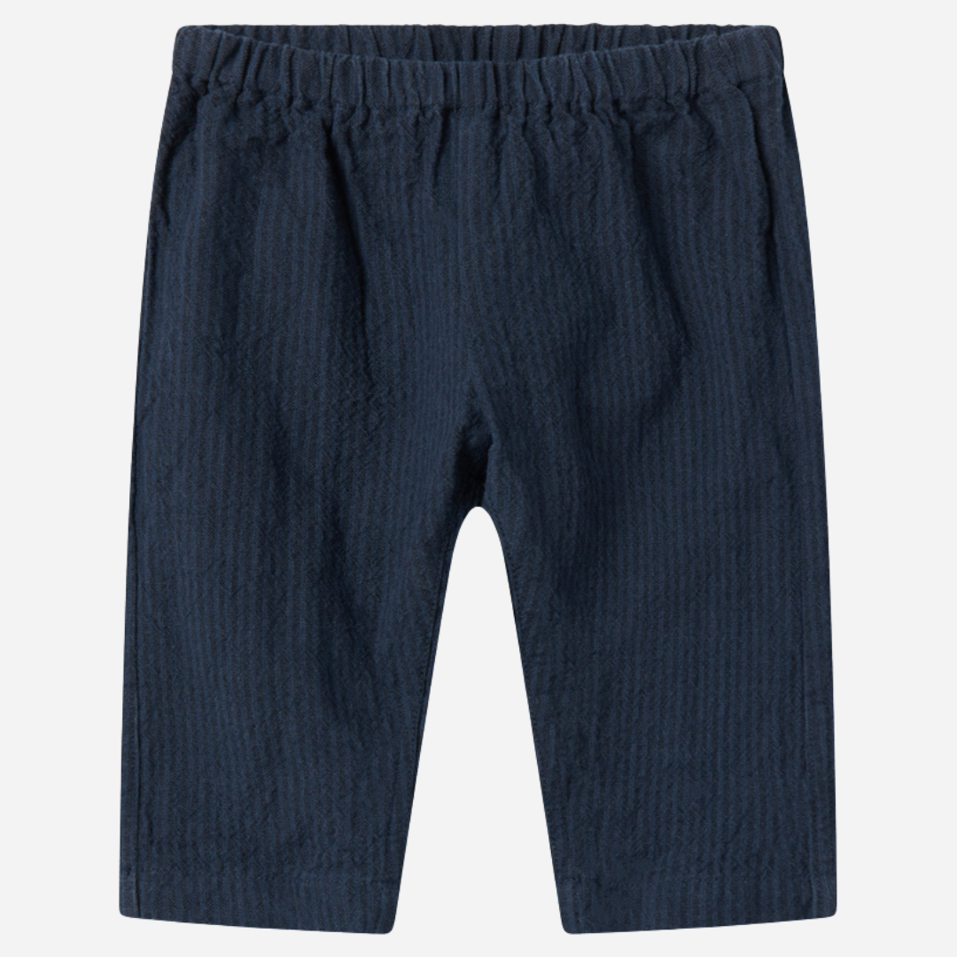 Sold at Bombon shop, designed by MarMar Copenhagen — navy 100% cotton textured baby pants with elastic waistband, part of a matching set.