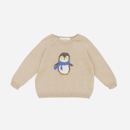 Sold at Bombon shop, designed by Fina Ejerique, a beige knit baby sweater with a penguin motif wearing a blue scarf. front