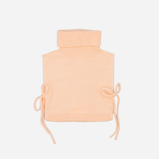 Sold at Bombon shop, designed by Fina Ejerique, pink knit vest with turtleneck and side ties, pairs perfectly with the floral blouse and beige textured skirt. front