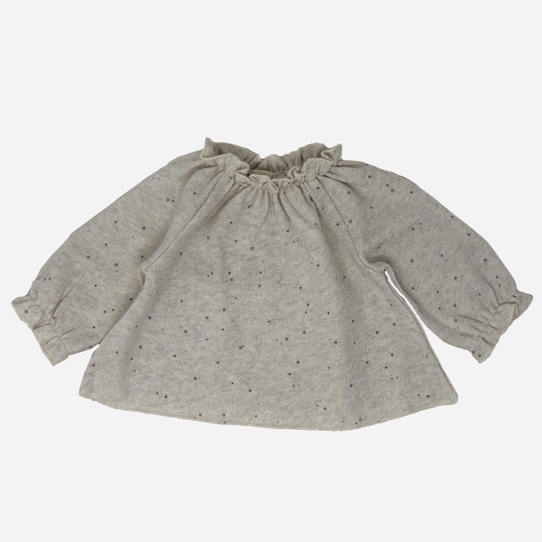 Sold at Bombon shop, designed by Tiny Soul — beige speckled knit baby blouse with gathered neckline and long puffed sleeves. front