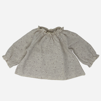 Sold at Bombon shop, designed by Tiny Soul — beige speckled knit baby blouse with gathered neckline and long puffed sleeves. front