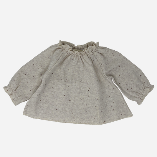 Sold at Bombon shop, designed by Tiny Soul — beige speckled knit baby blouse with gathered neckline and long puffed sleeves. front