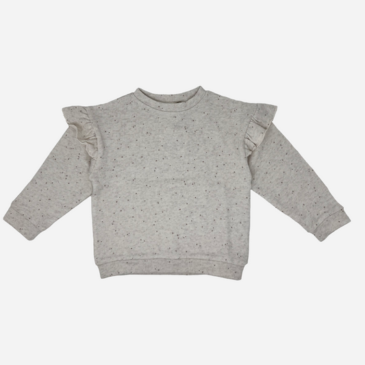 Sold at Bombon shop, designed by Tiny Soul — beige speckled baby sweatshirt with shoulder ruffles and long sleeves. front
