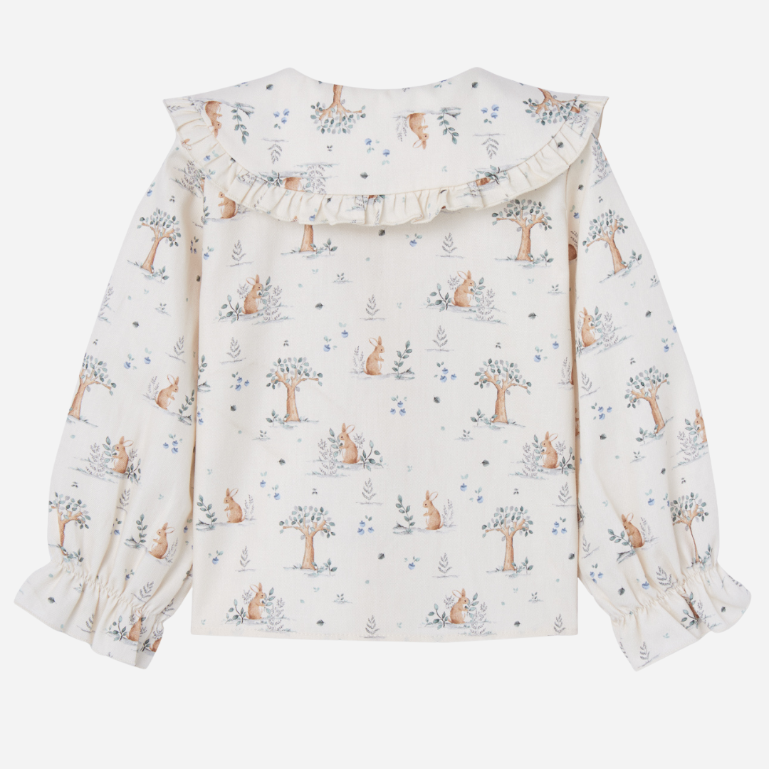 Sold at Bombon shop, designed by Paz Rodriguez. Cream bunny-print blouse with wooden buttons and ruffled collar, perfect paired with the Pompon Shorts and Cardigan in brown.