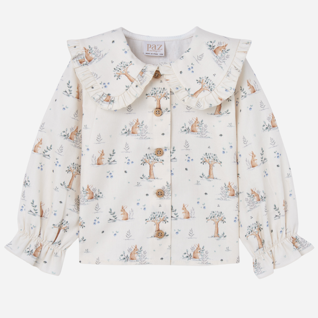Sold at Bombon shop, designed by Paz Rodriguez. Cream bunny-print blouse with wooden buttons and ruffled collar, perfect paired with the Pompon Shorts and Cardigan in brown.