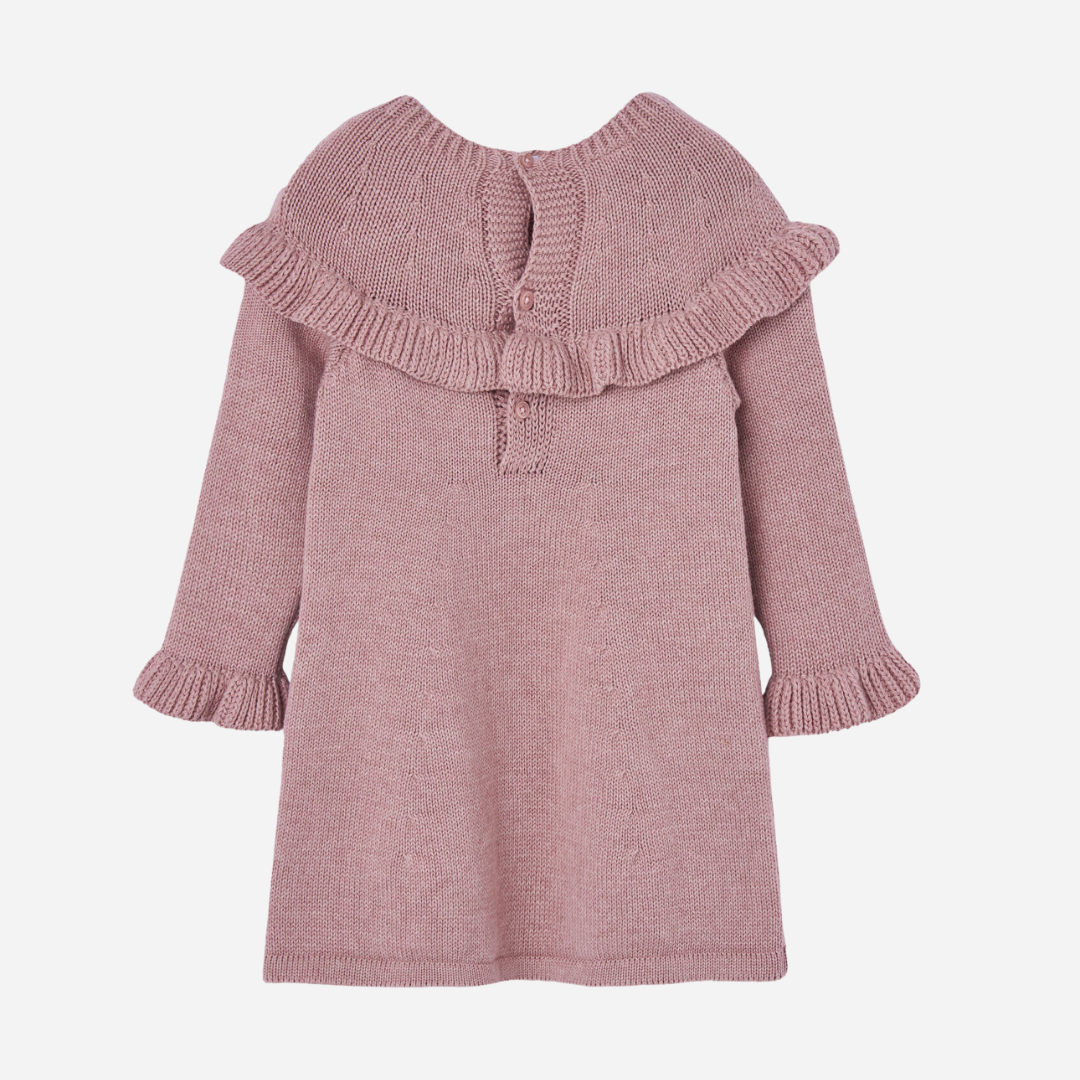Sold at Bombon shop, designed by Paz Rodriguez. Pink knitted baby girl dress with ruffle trim, long sleeves, and pom-pom detail on the chest. back