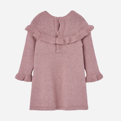 Sold at Bombon shop, designed by Paz Rodriguez. Pink knitted baby girl dress with ruffle trim, long sleeves, and pom-pom detail on the chest. back