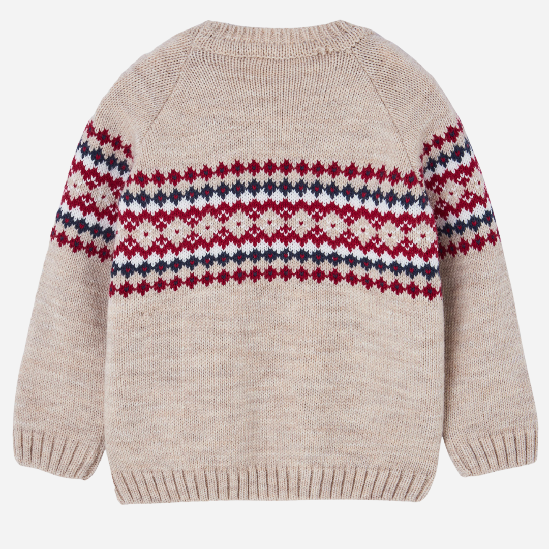 Sold at Bombon shop, designed by Paz Rodriguez. Beige knit sweater with red, navy, and ivory Nordic pattern across chest and sleeves.