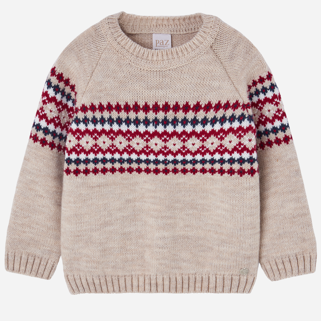 Sold at Bombon shop, designed by Paz Rodriguez. Beige knit sweater with red, navy, and ivory Nordic pattern across chest and sleeves.