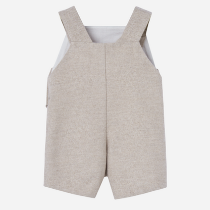 Sold at Bombon shop, designed by Paz Rodriguez. Beige herringbone baby overall with buttoned straps and side flap details.