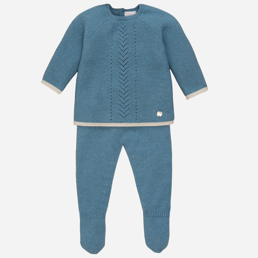 Sold at Bombon shop, designed by Paz Rodriguez, baby boy two-piece blue knit set with long-sleeve top featuring pointelle detail and matching footed pants with beige trim.