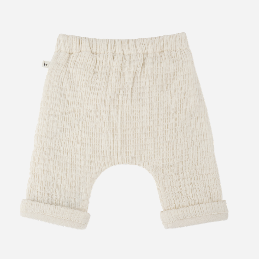 Sold at Bombon shop, designed by 1+ in the family — cream textured cotton muslin baby pants with rolled cuffs and adjustable drawstring waist. back